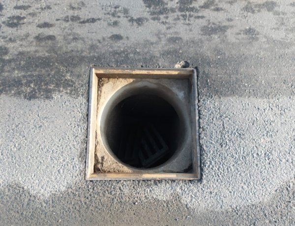 Eltört csapadékelvezető rácsot pótolnak a szakemberek a Tünde utcán